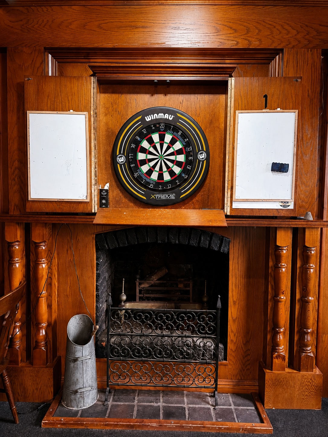 Winmau dartboard above a traditional fireplace at The Crown and Anchor Inn, Newport