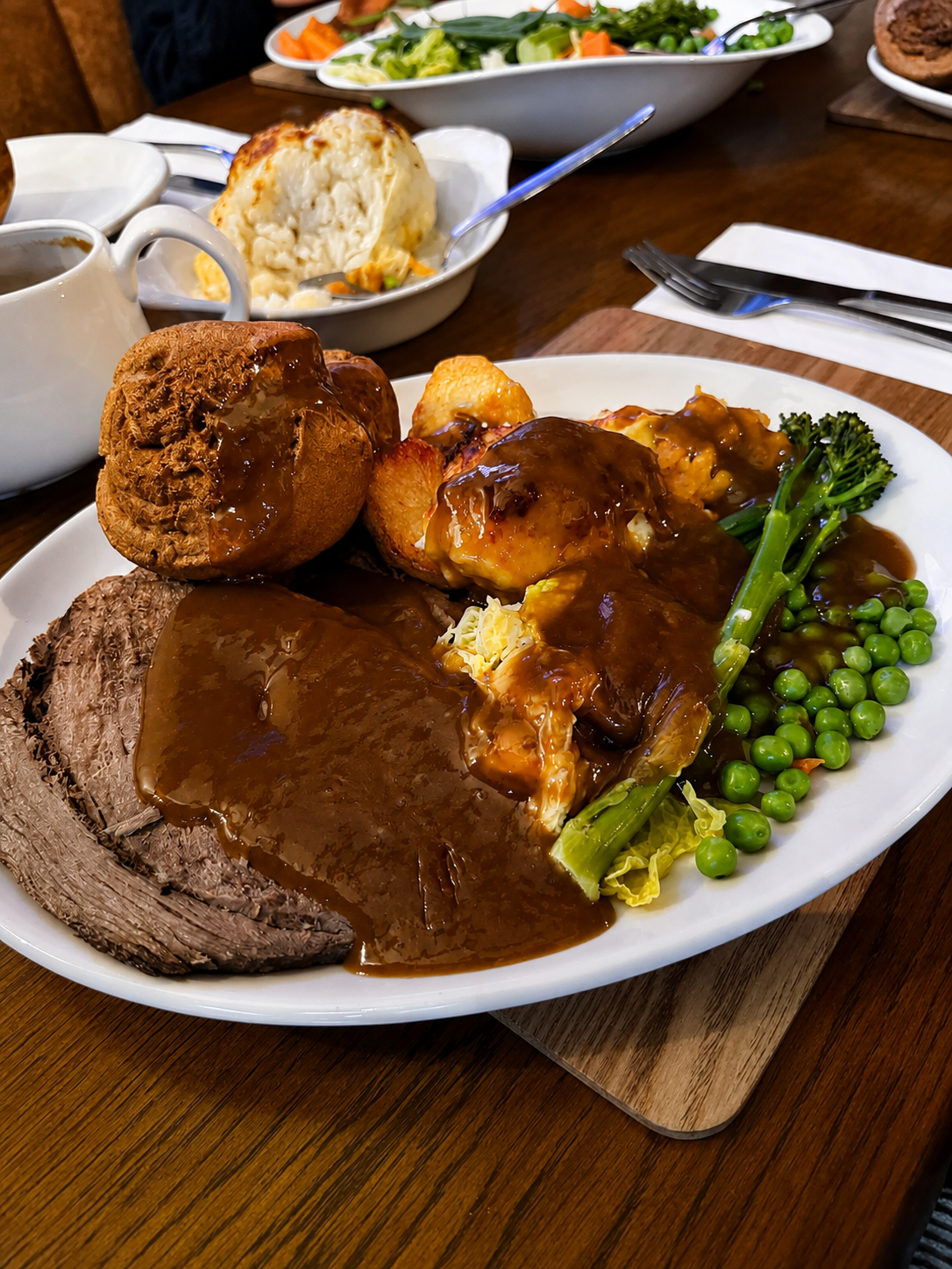 Sunday roast dinner — beef, roast potatoes, Yorkshire pudding, peas, broccoli and gravy