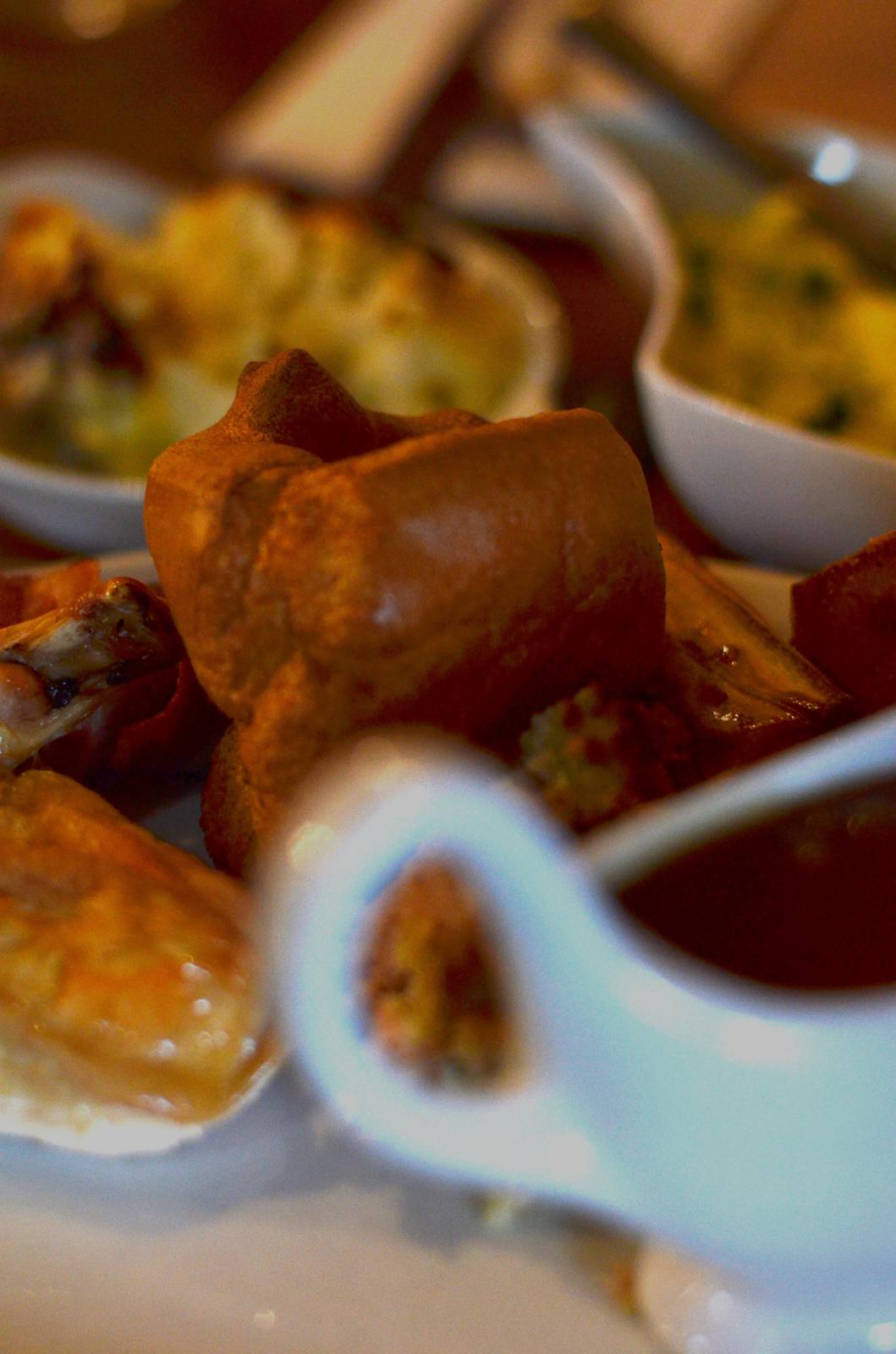 Sunday roast spread — Yorkshire puddings, sides and a gravy boat